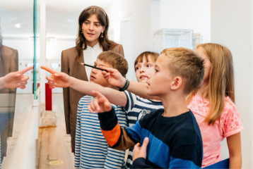 children pointing at classroom wall